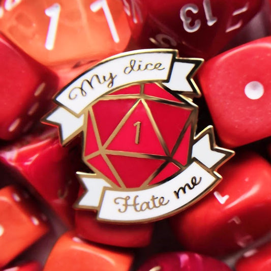 A red enamel pin with a gold-plated border and the text 'MY DICE HATE ME' in the center, designed for tabletop RPG enthusiasts.
